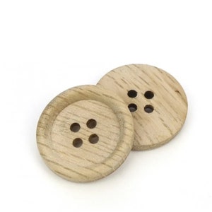 May include: Two wooden buttons with four holes each. The buttons are light brown and have a natural wood grain.