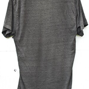 May include: A dark gray t-shirt with short sleeves and a crew neck.
