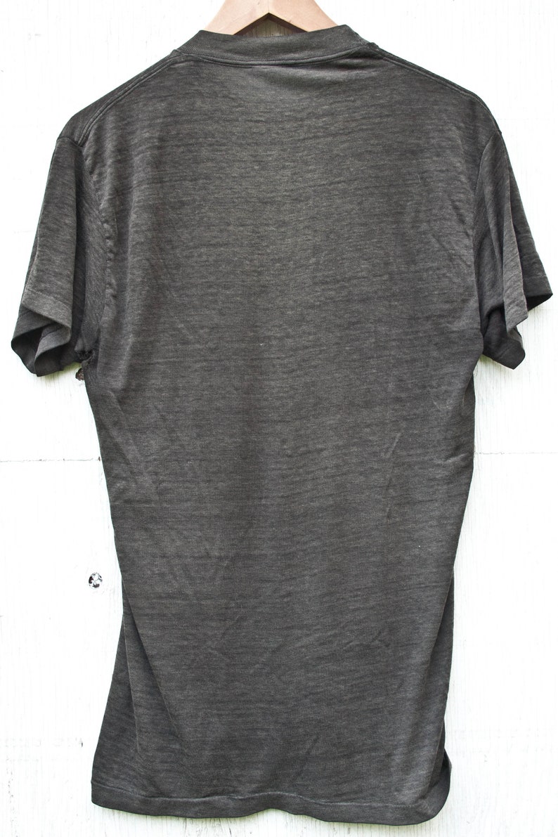 May include: A dark gray t-shirt with short sleeves and a crew neck.