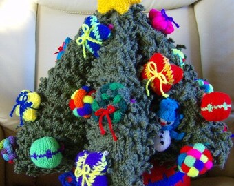 Könnte beinhalten: Ein gestrickter Weihnachtsbaum mit einem gelben Stern oben, geschmückt mit bunten Ornamenten, darunter ein Schneemann, Geschenke und Kugeln. Der Baum steht in einem roten Topf.