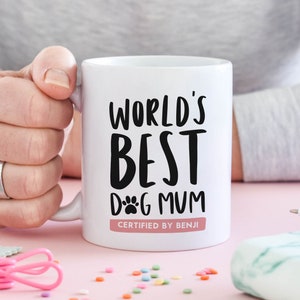 11oz ceramic mug personalised gift for dog lover and dog mum gift that reads "World's best dog mum certified by [chosen dog name here]" in black and white typography with an illustration of a dog paw