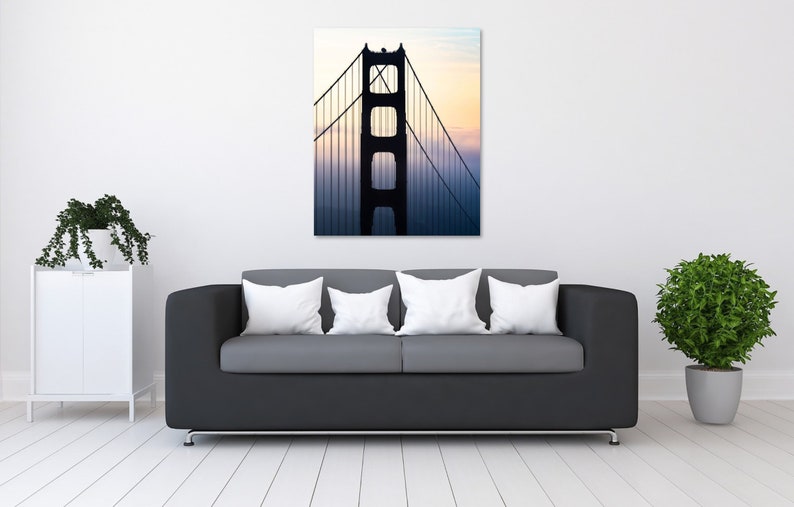 May include: A black and white photo of the Golden Gate Bridge in San Francisco, California. The bridge is silhouetted against a foggy, colorful sky.