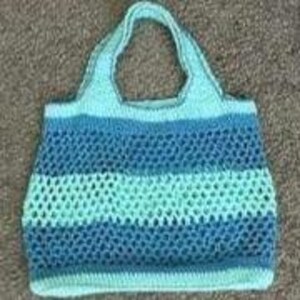 May include: A crocheted tote bag with a blue and turquoise striped design. The bag has a wide, flat base and a single handle.