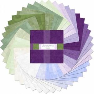 May include: A collection of 24 fabric squares in shades of green, purple, and blue. The squares are arranged in a fan shape and feature a subtle textured pattern. The fabric is labeled "Lavender Dreams".