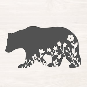 May include: Silhouette of a gray bear with white floral designs on its body. The bear is walking to the right.