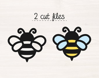 May include: Two bee illustrations, one black and white and one with yellow and blue accents. The text "2 cut files" is above the bees.