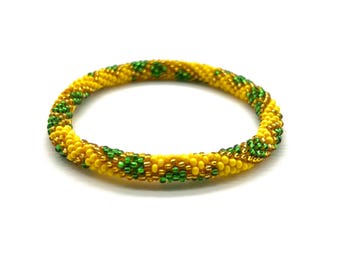 May include: A yellow and green beaded bracelet with a spiral pattern.