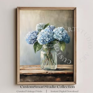 May include: A framed painting of blue hydrangeas in a clear glass jar on a wooden surface. The artwork has a vintage aesthetic, with soft lighting and a neutral background. The text "CustomSmartStudio Collection" is at the bottom.
