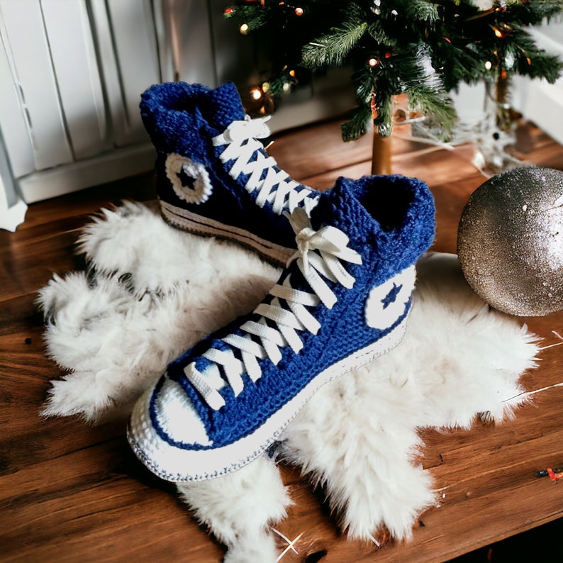 Home blue knitted high top sneakers with white laces and white star accents.