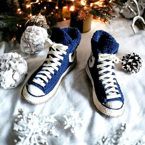 Cozy blue knitted high top sneakers with white laces and white soles.
