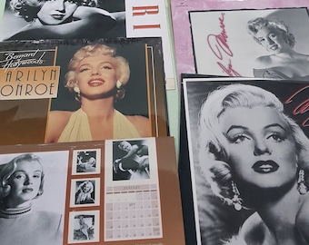 May include: A collection of Marilyn Monroe calendars and posters. The items feature black and white and color images of the actress. Some calendars have the text "Marilyn" and "Bernard Hollywoods Marilyn Monroe".