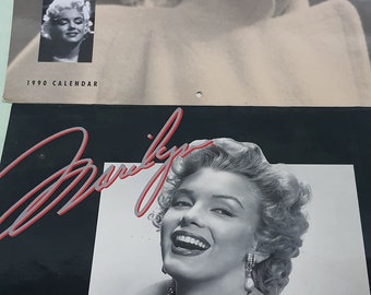 May include: A black and white calendar featuring Marilyn Monroe. The top half shows a profile image of her, while the bottom half displays a smiling portrait. The calendar is labeled "1990 CALENDAR".