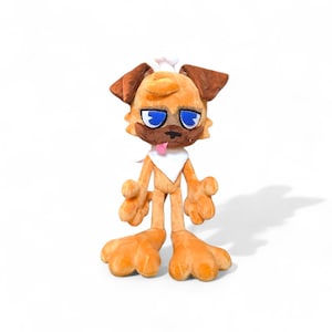 May include: A plush toy dog wearing a chef's hat, with brown ears and blue eyes. The dog has a white bib and a pink tongue. The toy is standing on its hind legs with its arms outstretched.