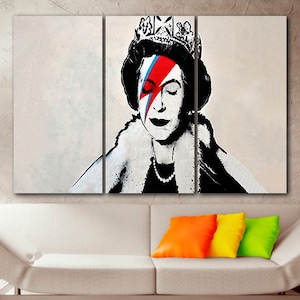 May include: A three-panel canvas print featuring a black and white portrait of Queen Elizabeth II with a red, blue, and white lightning bolt painted over her right eye. The queen is wearing a crown and a fur collar.