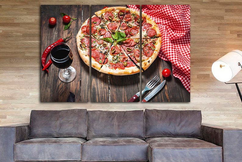 Puede incluir: Una impresi&oacute;n en lienzo de tres paneles que presenta un primer plano de una pizza de pepperoni con aceitunas verdes y albahaca sobre una mesa de madera con una copa de vino tinto, pimientos rojos y un mantel a cuadros rojo y blanco.