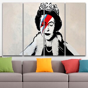 May include: A multi-panel canvas print featuring a black and white portrait of Queen Elizabeth II with a red, blue, and white lightning bolt design over her eye, reminiscent of David Bowie's iconic "Aladdin Sane" album cover.