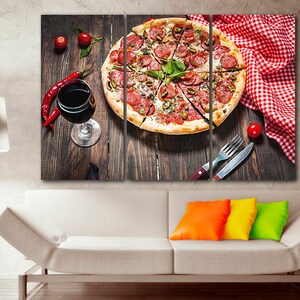 Puede incluir: Una impresi&oacute;n en lienzo de tres paneles que presenta un primer plano de una pizza de pepperoni y aceitunas verdes con una copa de vino tinto y pimientos rojos sobre una mesa de madera. La pizza est&aacute; cortada en rodajas y adornada con albahaca fresca.