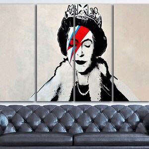 May include: A three-panel canvas print featuring a black and white portrait of Queen Elizabeth II with a red, blue, and white lightning bolt painted over her right eye. The queen is wearing a crown and a fur collar.