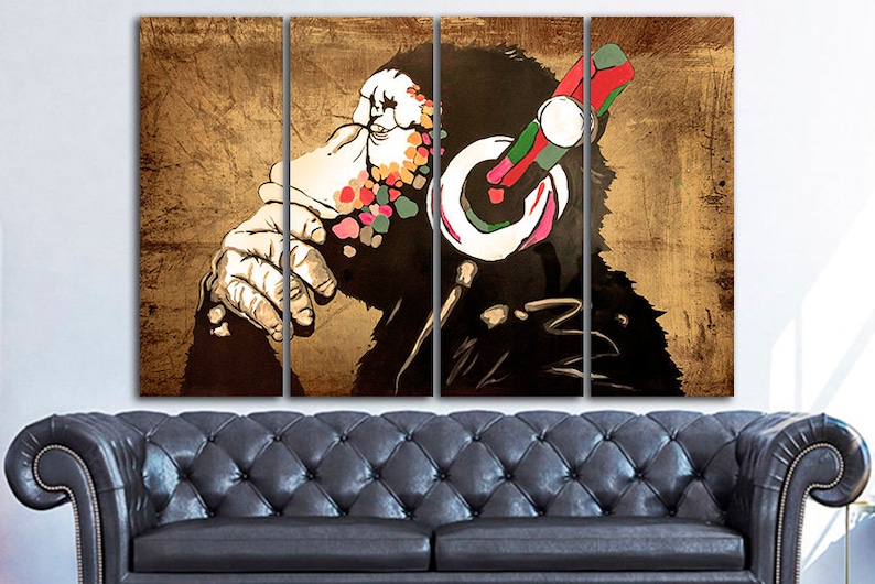Op de afbeelding: Een meerdelige canvasprint met een gestileerde illustratie van een aap met een koptelefoon. Het gezicht van de aap is bedekt met kleurrijke verfspatten, en de achtergrond is een getextureerd bruin.