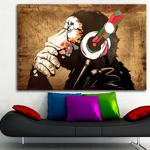 Op de afbeelding: Een kleurrijk abstract schilderij van een aap met een koptelefoon. De aap is afgebeeld in een zwart-wit silhouet met kleurspatten op zijn gezicht en koptelefoon. De achtergrond is een bruin, getextureerd canvas.