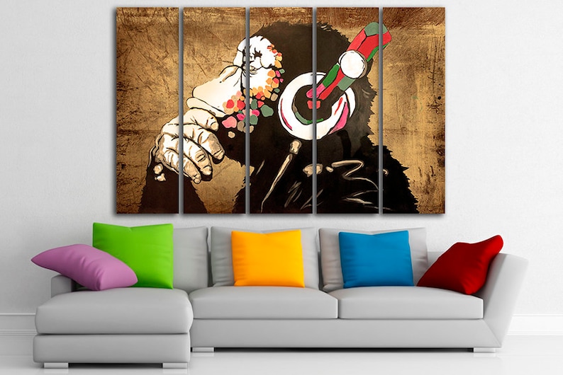 Op de afbeelding: Een meerdelige canvasprint met een gestileerde illustratie van een aap met een koptelefoon. Het gezicht van de aap is bedekt met kleurrijke stippen en de achtergrond is een getextureerd bruin.