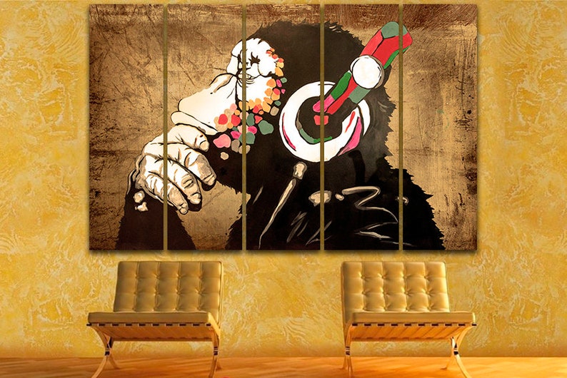 Op de afbeelding: Een meerpaneels canvasprint met een kleurrijke, gestileerde illustratie van een aap met een koptelefoon. Het gezicht van de aap is gedeeltelijk bedekt door de koptelefoon en de achtergrond is van een getextureerde, bruine kleur.