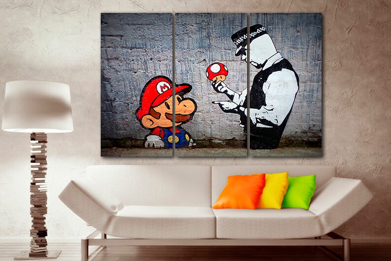 Pu&ograve; includere: Una stampa su tela a tre pannelli con un personaggio dei cartoni animati che assomiglia a Mario della serie di videogiochi Super Mario Bros. fermato da un agente di polizia. Il personaggio tiene un fungo rosso. Lo sfondo &egrave; un muro di mattoni.