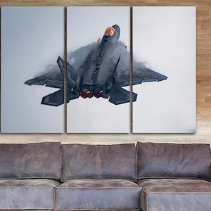 May include: A three-panel canvas print featuring a close-up of a grey fighter jet flying through the clouds. The jet is in mid-flight and the clouds are swirling around it. The canvas print is a great way to add a touch of modern art to your home.