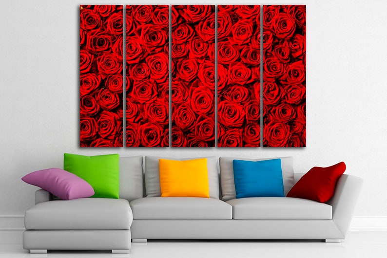 May include: A multi-panel canvas print featuring a close-up of a wall of red roses. The print is displayed on a white wall above a gray couch with colorful throw pillows.