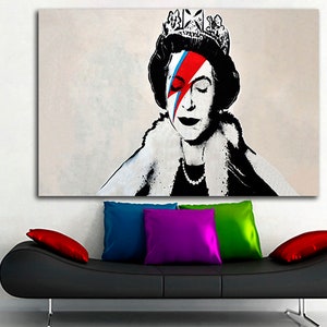May include: A black and white portrait of Queen Elizabeth II with a red, blue, and white lightning bolt painted over her right eye. The queen is wearing a crown and a fur collar.