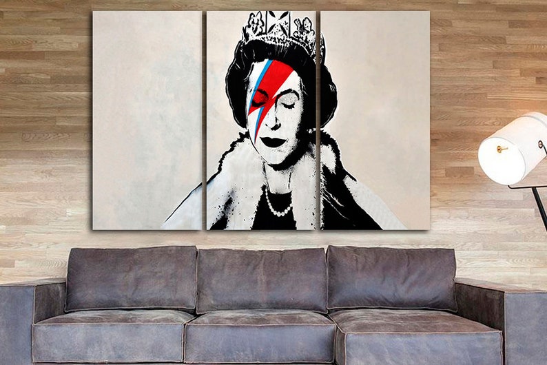 May include: A three-panel canvas print featuring a black and white portrait of Queen Elizabeth II with a red, blue, and white lightning bolt painted over her right eye. The queen is wearing a crown and a fur collar.