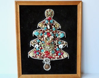 May include: A framed Christmas tree made of various beads, buttons, and other trinkets. The tree is red, blue, gold, and white and is set against a black velvet background.