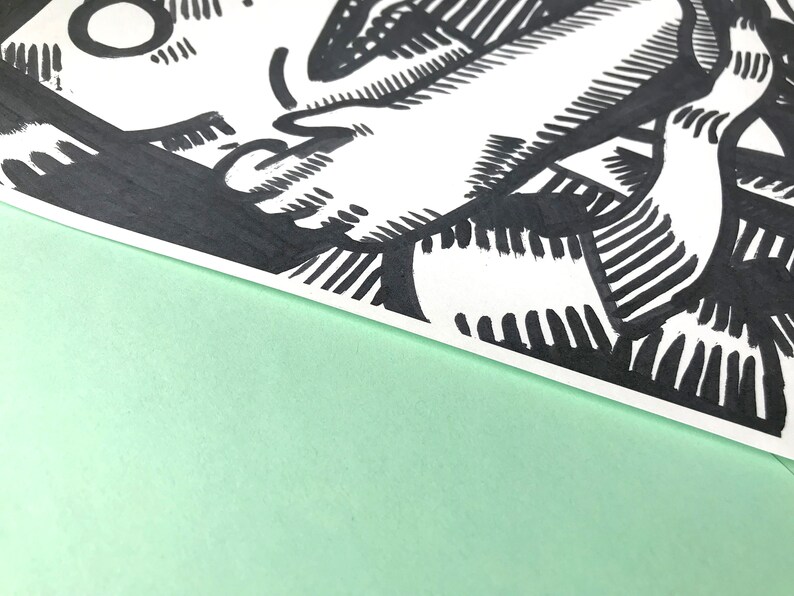 May include: Black and white line art drawing of a cartoon character with a large, expressive mouth and a single eye. The character is drawn in a bold, graphic style.
