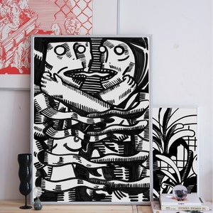 May include: Black and white illustration of two faces intertwined, creating a complex pattern of lines and shapes. The artwork is framed and displayed on a wooden shelf.