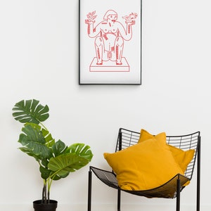 May include: A red line drawing of a person with outstretched arms holding birds in each hand. The drawing is framed in black and hanging on a white wall. A yellow pillow sits on a black wire chair in the foreground.