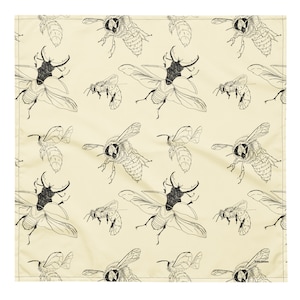 Op de afbeelding: Een beige stof met een herhalend patroon van zwart-wit illustraties van bijen en kevers. Het patroon is een eenvoudige lijntekening stijl.