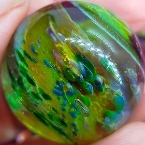 Handmade marble, from Borosilicate Glass. Has lovely bright lustres and sparkles,  as well as transparent blue effects.