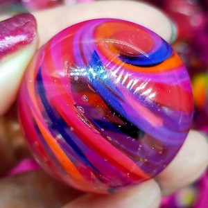 Handmade marble, made with Borosilicate Glass, beautiful ruby reds, fushia, oranges and blue colors.