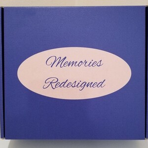 May include: A blue box with a pink oval label that says "Memories Redesigned".
