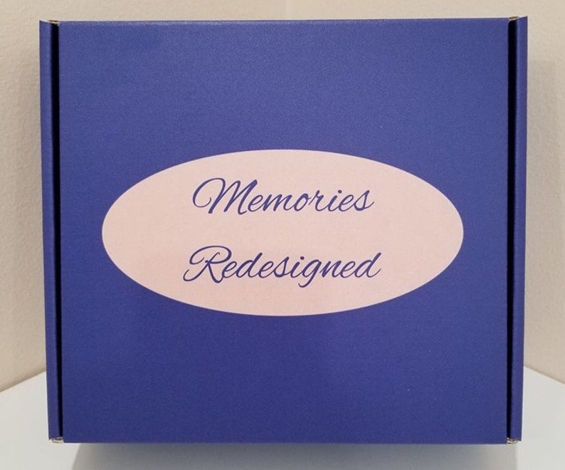 May include: A blue box with a pink oval label that says "Memories Redesigned".