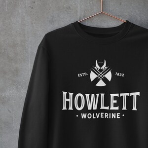 May include: Black sweatshirt with a white graphic design featuring a stylized claw mark and the text "ESTD. 1832 HOWLETT WOLVERINE."