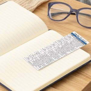 May include: An open notebook with lined pages and a small card with the text "FOREVER MY GLASS" on it. The card is a list of different types of glass.