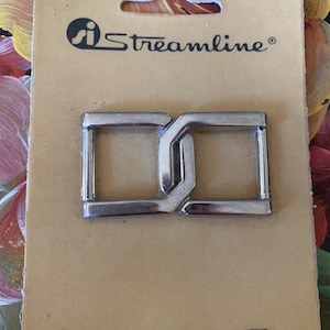 May include: A silver metal buckle with a double-loop design. The buckle is packaged on a card with the brand name "Streamline" and the product number "C8507 3/4" 81 04".