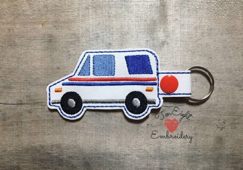 May include: White mail truck keychain with red, white, and blue details. The keychain has a red button and a silver key ring. The text "Ten Eight Embroidery" is visible in the bottom right corner.