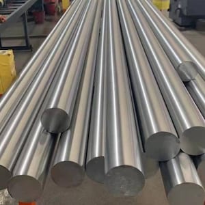 May include: A close-up of a pile of shiny, silver metal rods. The rods are round and have a smooth, polished finish.