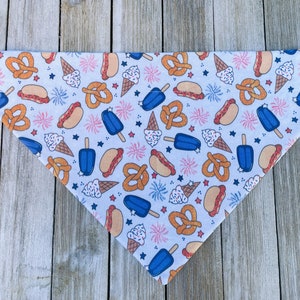 Może przedstawiać: Biała bandana dla psa z niebieskim, pomarańczowym i białym wzorem lod&oacute;w w wafelkach, hot dog&oacute;w, precli i fajerwerk&oacute;w.