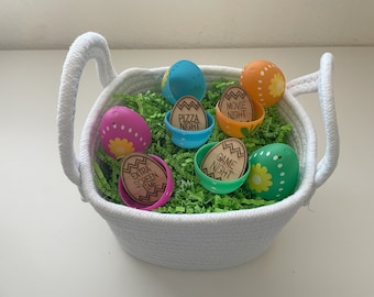 May include: A white basket filled with plastic Easter eggs. Each egg contains a wooden token with a different activity written on it, such as "Movie Night", "Pizza Night", and "Game Night".