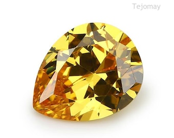 May include: A pear-shaped, yellow gemstone with a faceted cut. The gemstone is set against a white background.