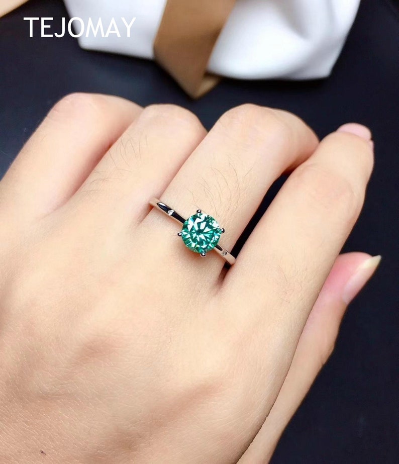 Green round moissanite engagement ring in sterling silver with brilliant sparkle and elegant design