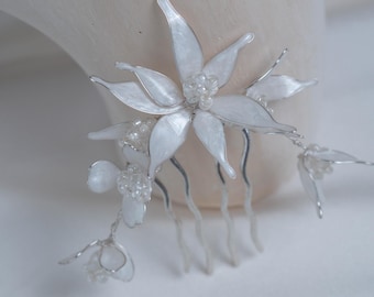Kam van bloemenhars, delicate bloesems, bruiloftsaccessoire, kapsel met laag knotje